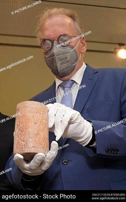 05 November 2021, Berlin: Reiner Haseloff (CDU), Minister-President of Saxony-Anhalt, holds a vasa from the Mayan culture in Guatemala at the Saxony-Anhalt...