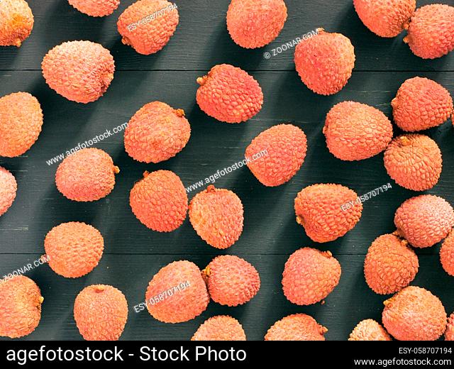 lichee fruit on dark wooden background close up as pattern. Top view or flat lay