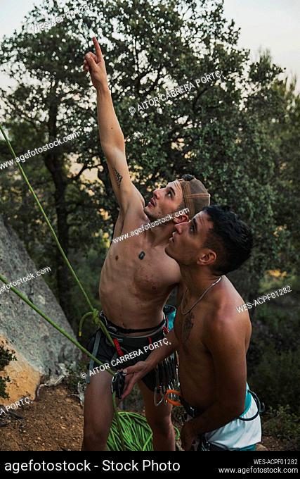 Male climber pointing while guiding athlete