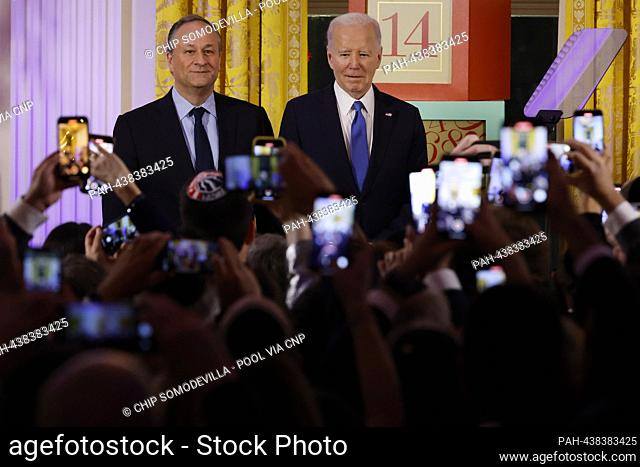 Second gentleman Doug Emhoff (L) and United States President Joe Biden host a Hanukkah holiday reception in the East Room of the White House on December 11
