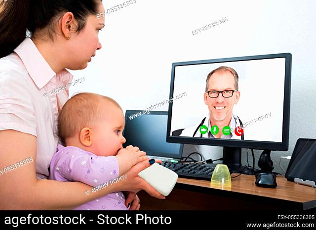 Woman With Her Baby Using Computer With Blank White Screen