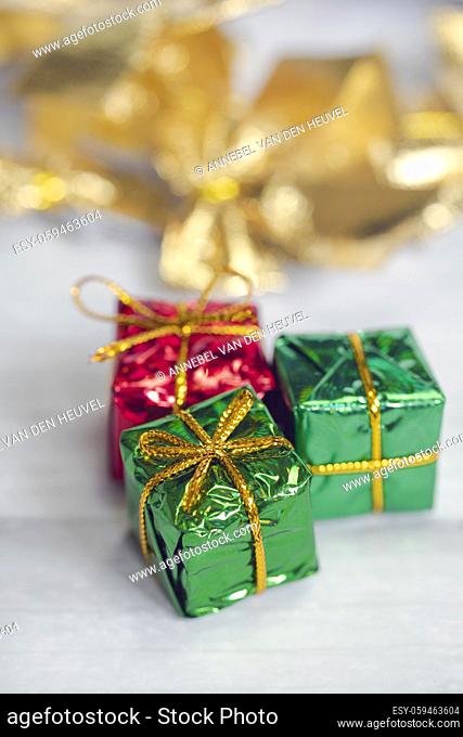 Pile of colored shiny gift boxes with copy space on white wood background, modern retro Christmas design, Colorful presents, Holiday concept space for text