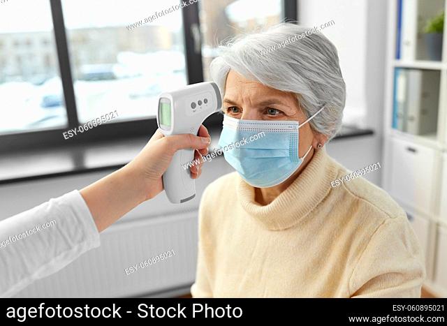 doctor with thermometer and woman at hospital