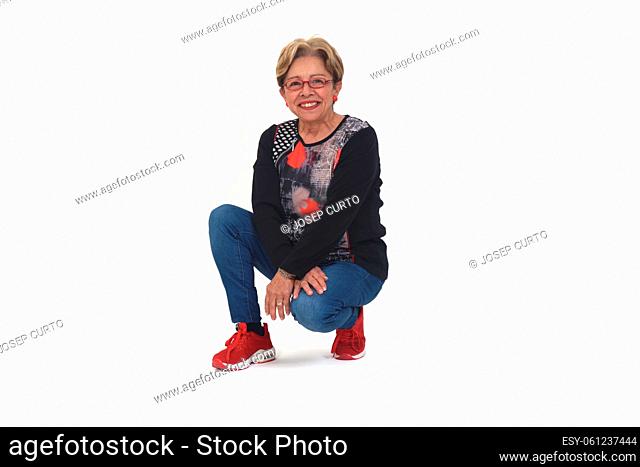 front view of a happy senior woman squatting on white backgrond
