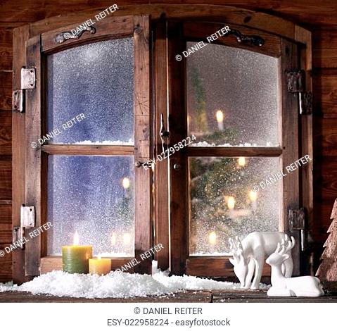 Snow Reindeer and Lighted Candles at Window Pane