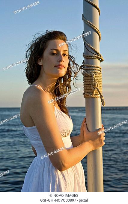 Young Woman Standing on Boat, Holding Mast, Portrait