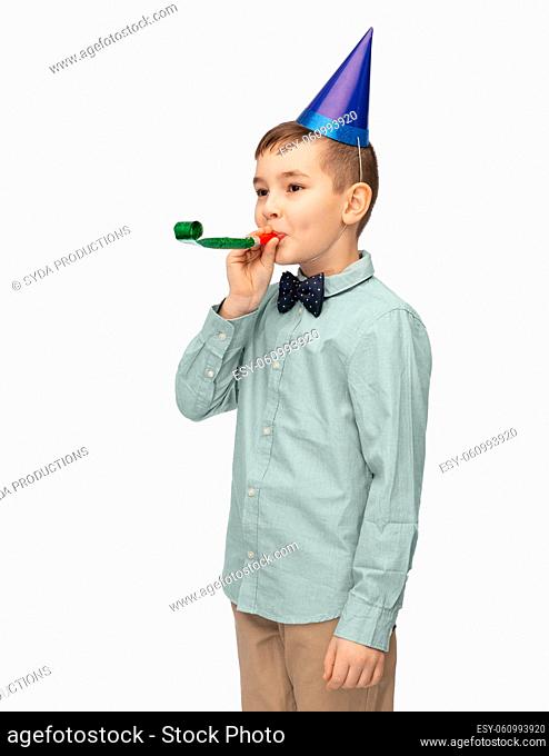 smiling boy in birthday party hat with blower