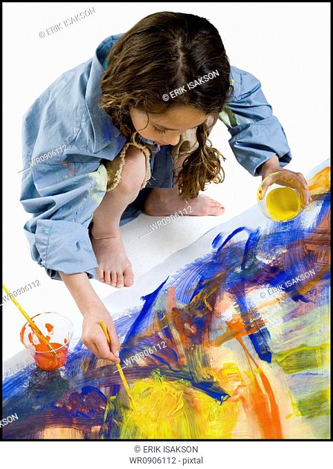 High angle view of a girl painting on the floor