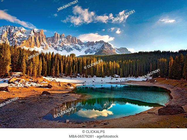Dolomites, The Carezza lake, with fir forests and the Latemar ridge in the background, at sunset