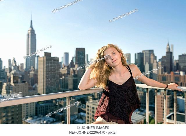 Blond woman standing in front of skyscrapers