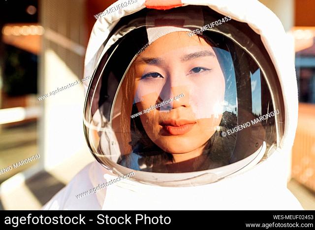 Serious female astronaut in space suit during sunny day