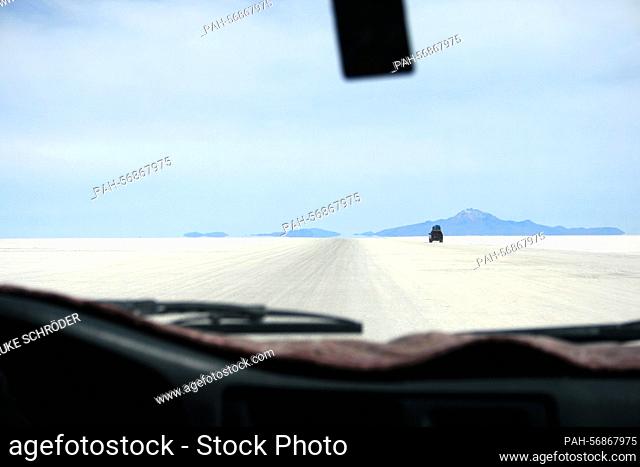 An off-road vehicle drives through the Salar de Uyuni, taken on October 17th, 2009, near Uyuni, Bolivia. The Salar de Uyuni is the largest salt pan in the world...