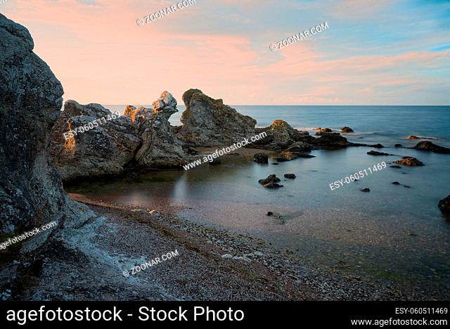 Kalksteinfelsen, sogeannte Raukar, an der Küste von Gotland, nördlich von Ljugarn bei Folhammar, im Licht der frühen Morgensonne. Langzeitbelichtung