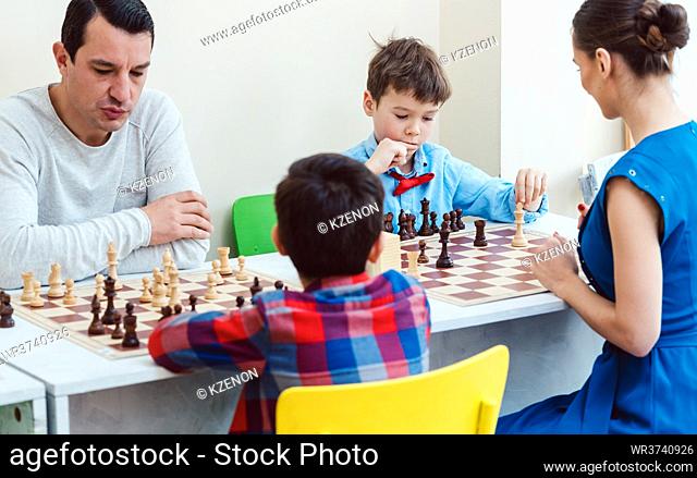 People playing a chess tournament or taking lessons