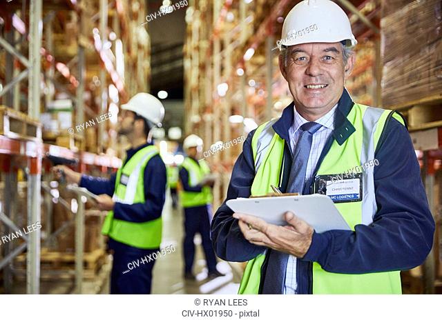 Portrait confident manager with clipboard in distribution warehouse