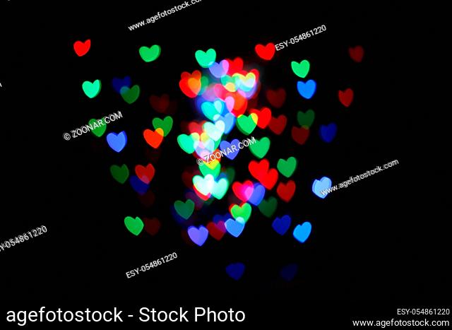 Hearts form bokeh. Multicolored blurred hearts on a black background