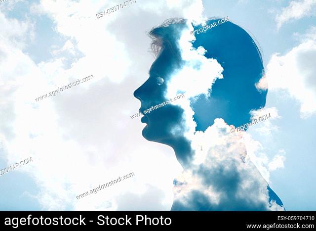 Psychology and man mental health contemplation and atmosphere pressure concept. Multiple exposure clouds and sun on male head silhouette