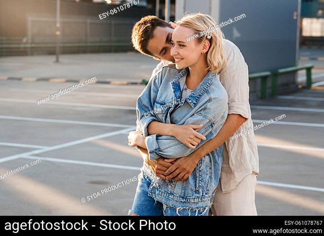 happy young couple hugging on city parking