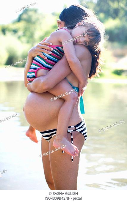 Pregnant mother holding young daughter