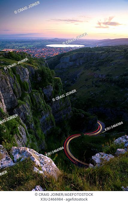 Cheddar Gorge in the Mendip Hills at dusk with traffic trails on the road below. Cheddar, Somerset, England