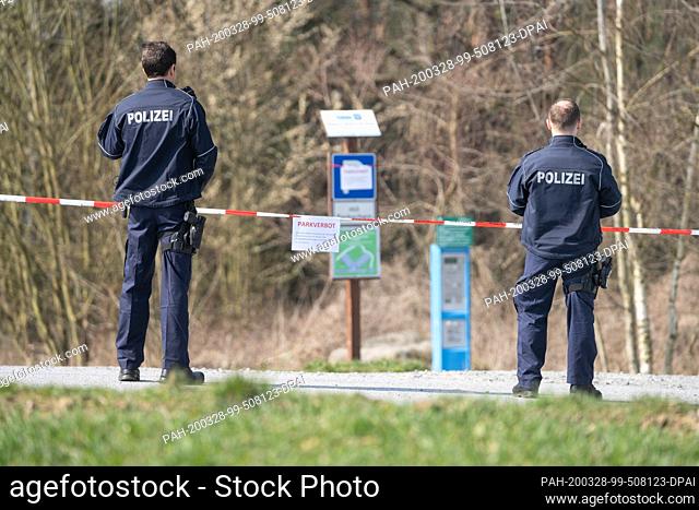 28 March 2020, Saxony, Rathen: Police officers are checking that the closure of an excursion parking lot near Rathen in Saxon Switzerland is being observed