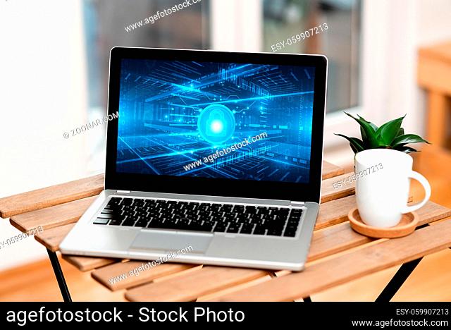 Laptop Resting On A Table Beside Coffee Mug And Plant Showing Work Process