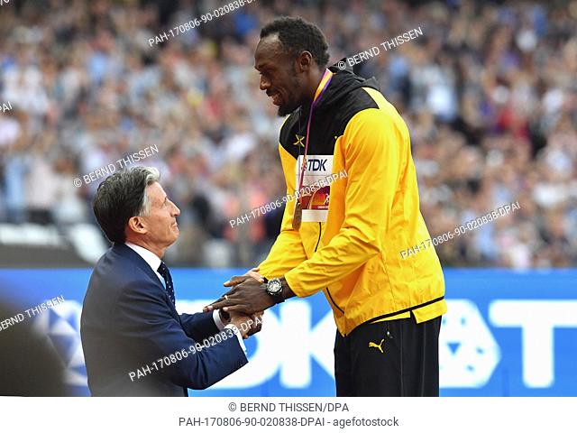 Usain Bolt of Jamaica (R) receives his bronze medal from IAAF President Sebastian Coe after the men's 100 m final at the IAAF World Championships in Athletics...