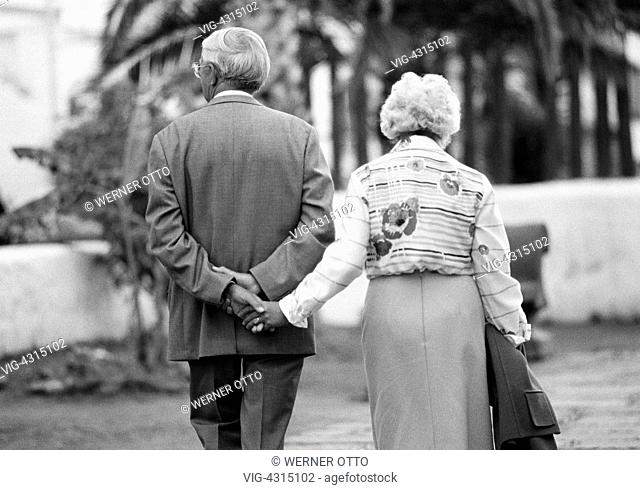 SPANIEN, PUERTO DE LA CRUZ, 15.04.1981, Eighties, black and white photo, people, elder people, older couple walking hand in hand, holding hands, suit, blouse