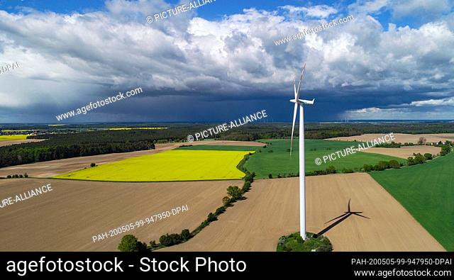 05 May 2020, Brandenburg, Sieversdorf: Dark rain clouds pass over yellow rape fields and green grain fields, meadows and forests in the Oder-Spree district in...