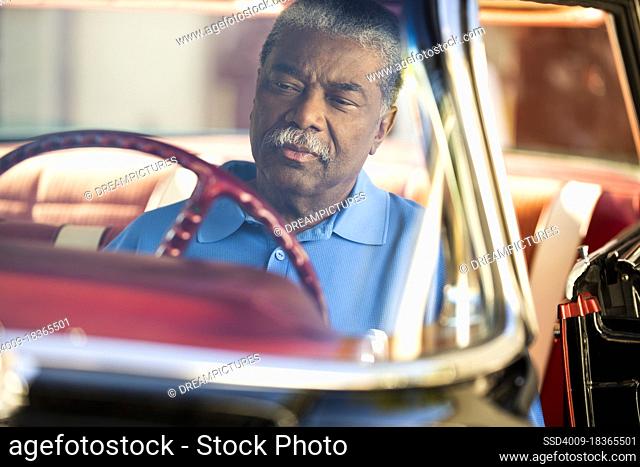 Older man sitting in drivers seat of 1960 Oldsmobile Super 88 Holiday Sport Sedan