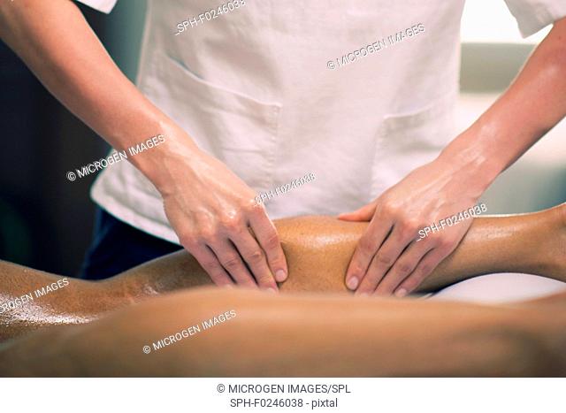 Sports massage. Physical therapist massaging man's calfs, applying strong finger pressure