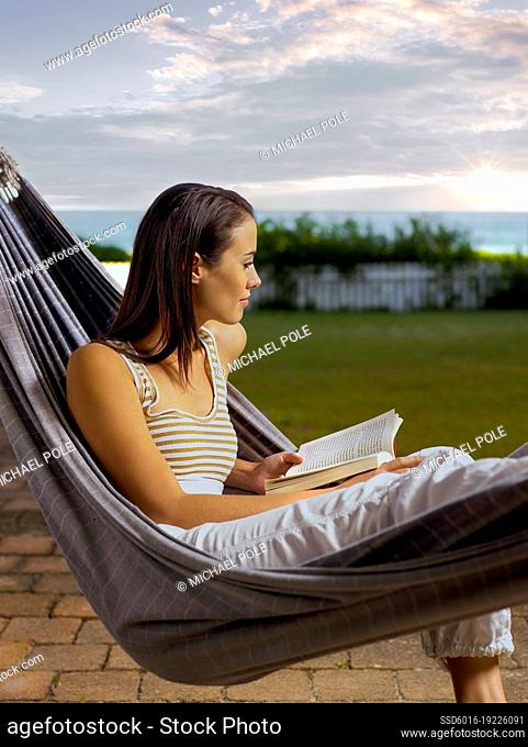 Woman in hammock reading a book
