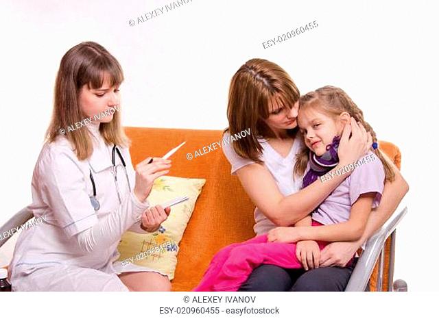 doctor looks temperature on a thermometer sick girl and her mother comforts