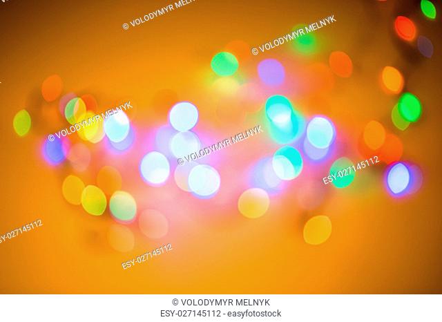 Colorful beautiful blurred bokeh background with copy space. Holiday texture. Glitter multicolored light spots on navy blue backdrop, defocused