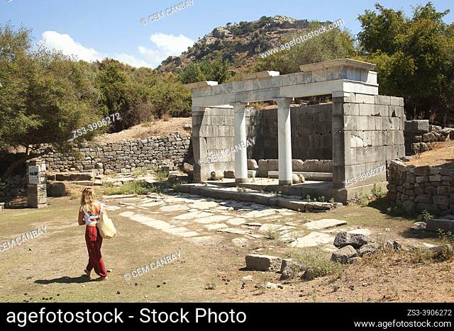 Tourist woman near The Fountain Building at the archaeological site of ancient Kaunos city , Dalyan, Mugla Province, Aegean Region, Turkey, Europe