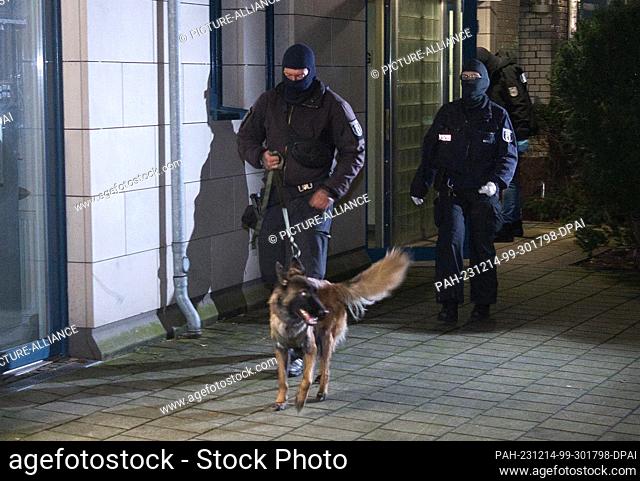 14 December 2023, Berlin: Police officers with a dog go to a house. The Federal Public Prosecutor's Office has arrested four suspected members of the Islamist...