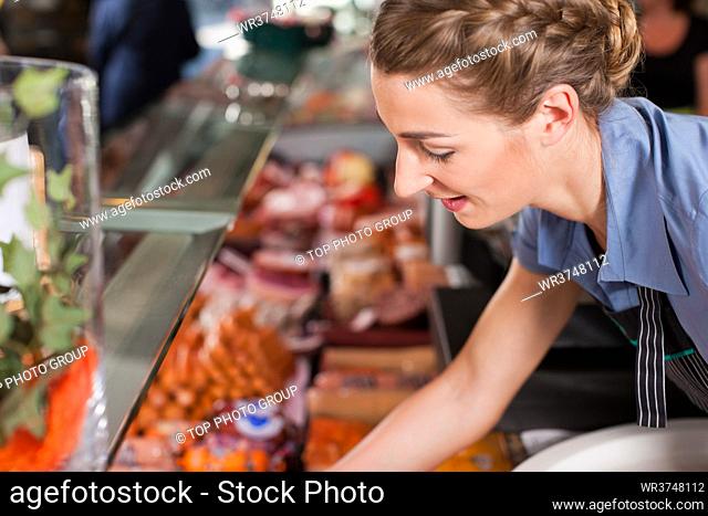 Female butcher picking fresh food for selling at butchery