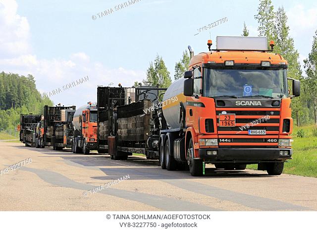 Kaarina, Finland - July 28, 2018: Roadworks asphalting machinery transport trucks parked on a freeway rest stop in summer in South of Finland