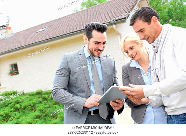 Real-estate-agent showing house plan on digital tablet