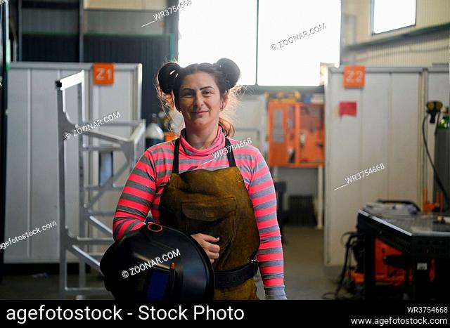 a portrait of a women welder holding a helmet and preparing for a working day in the metal industry. High quality photo