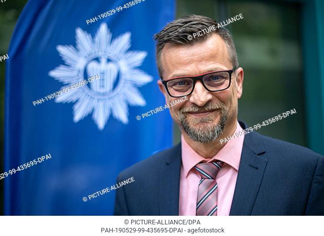 29 May 2019, Bavaria, Munich: Stefan Pfeiffer, head of the traffic police Feucht, stands in front of a flag with the coat of arms of the German Police Union...