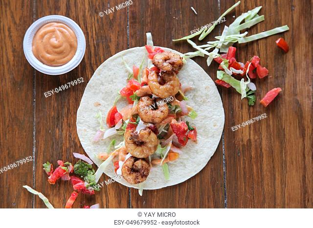 Prawn tortilla tacos open face wrap on wooden background