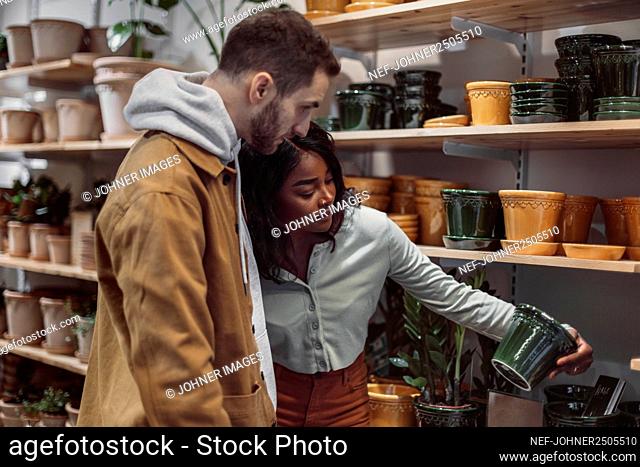 Couple looking at flower pots in shop