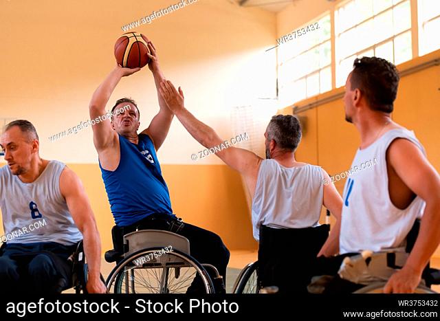 handicapped war veterans in wheelchairs with professional equipment play basketball matches in the hall. the concept of sports with disabilities