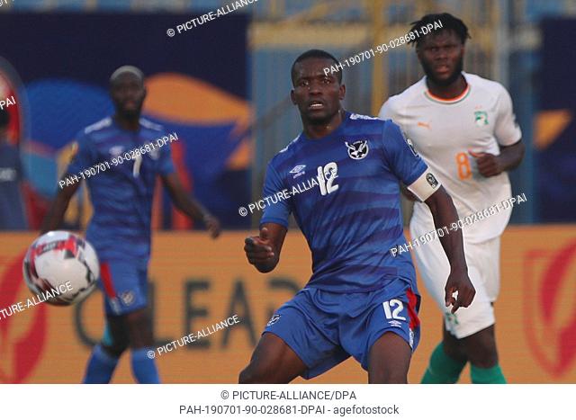 01 July 2019, Egypt, Cairo: Namibia's Ronald Ketjijere (C), Ivory Coast's Franck Kessie battle for the ball during the 2019 Africa Cup of Nations Group C soccer...