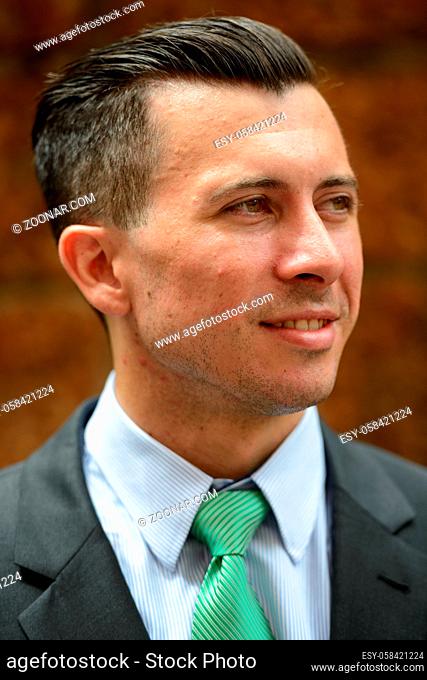 Portrait of young handsome businessman in suit against brick wall