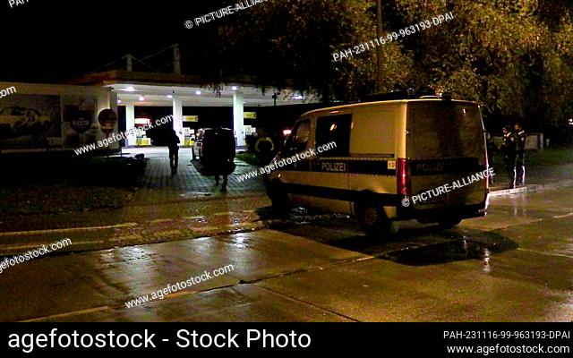 16 November 2023, Berlin: A police vehicle is parked near a petrol station next to police officers. A body was found in Berlin late on Wednesday evening