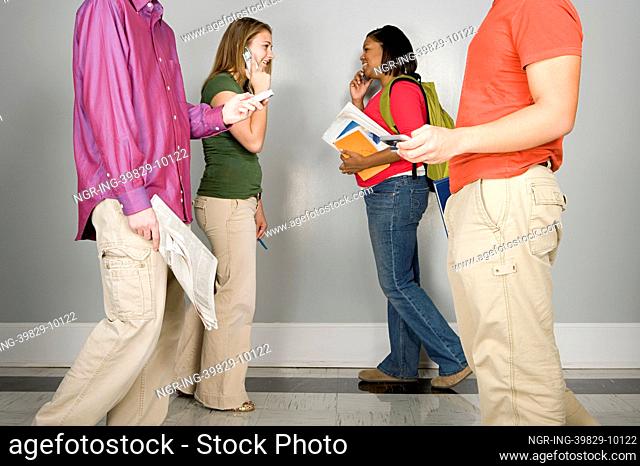 Four students walking along a corridor