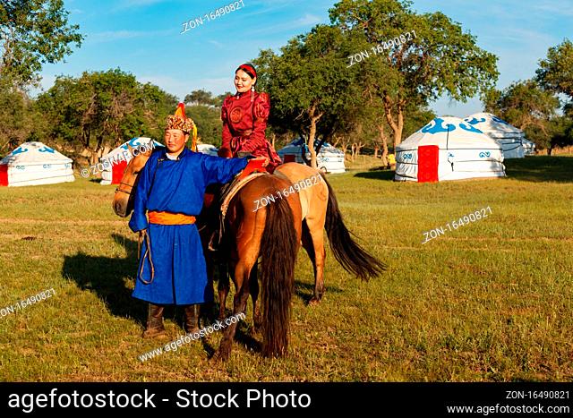 Mongolian couple with her traditional and colorful dress in front of the yurt