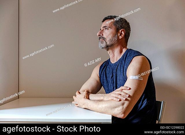 France, Man with bandage on arm sitting at table